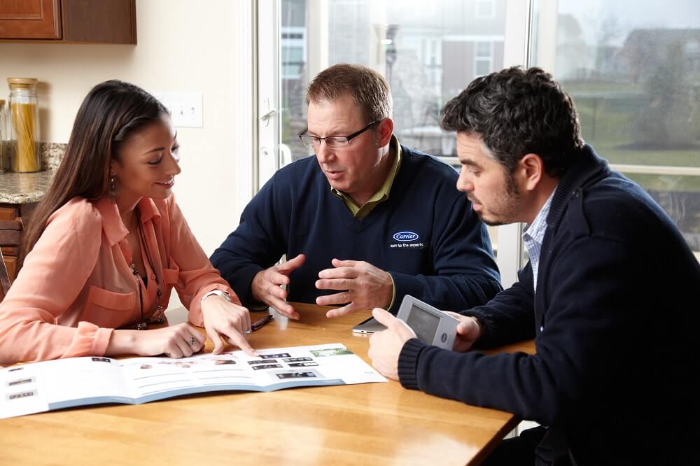 hvac tech talking with homeowners at table