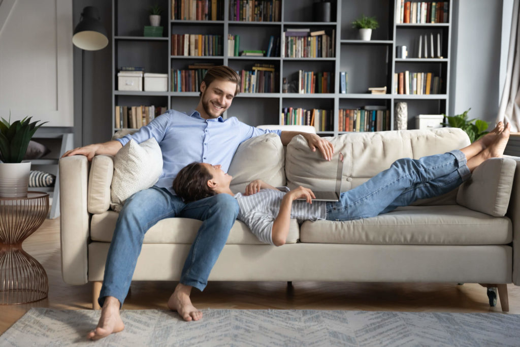A happy couple relaxing on the couch at home..
