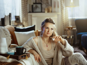 Woman sits comfortably in her home