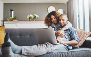 couple on laptop enjoying comfort of home